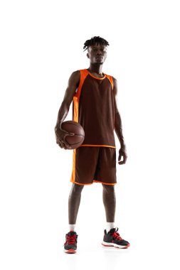 Dikey portre. Genç Afrikalı bir adam, basketbolcu. Beyazların arka planında izole edilmiş top oynuyor..