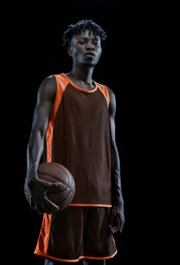 Topla poz veren Afrikalı profesyonel bir basketbolcunun dikey portresi..