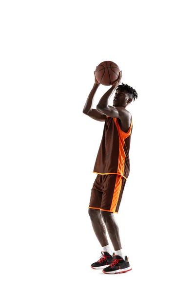 Ritratto verticale. Giovane uomo africano, giocatore di basket praticare con la palla isolata su sfondo bianco studio. — Foto Stock