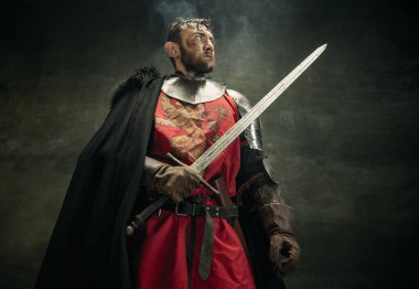 Vahşi sakallı bir adam, Medeival savaşçı ya da kılıç tutan kirli yüzlü bir şövalye..