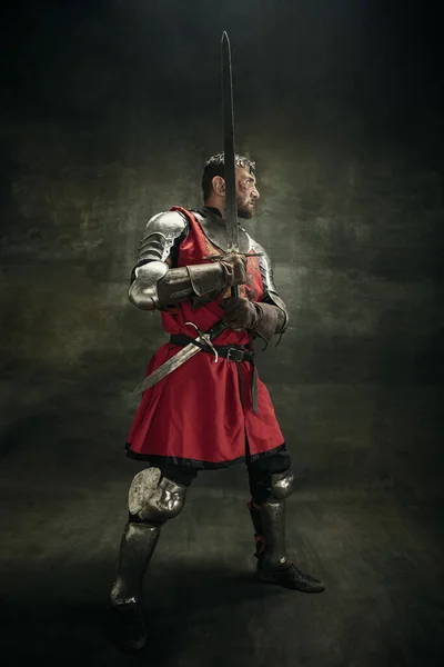 Portrait d'un homme barbu brutal, guerrier médéival ou chevalier au visage sale et blessé tenant l'épée — Photo