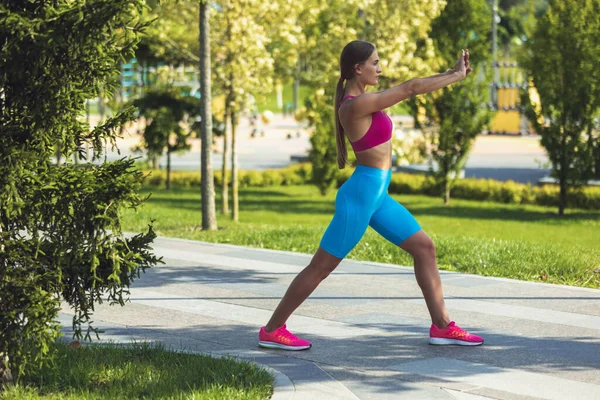 Genç, zayıf, sportif beyaz kadın spor yapıyor, spor yapıyor, parkta ya da şehir sokaklarında yoga yapıyor.. — Stok fotoğraf