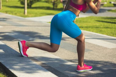 Parlak pembe ayakkabılı kadın kaslı bacaklarının kırpılmış görüntüsü..