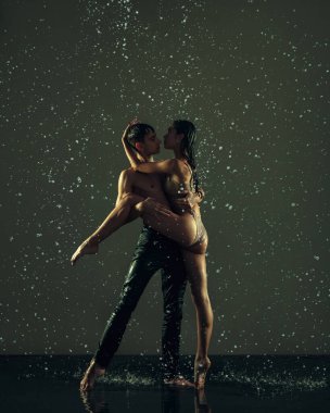 İki genç balerin, arka planda yağmur damlalarında dans eden kadın ve erkek. Sanat, eylem, ilham kavramı.