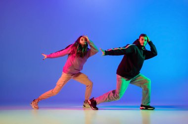İki genç insan, erkek ve kadın, dans eden fren dansı, mavi arka planda hip-hop.
