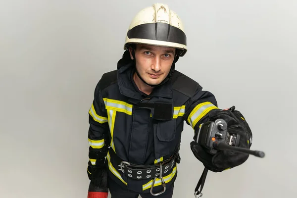 Un bombero masculino vestido de uniforme posando sobre fondo blanco del estudio. —  Fotos de Stock