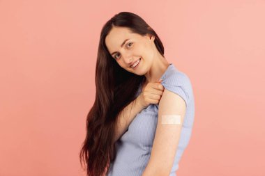 Aşılama. Pembe pastel arka planda soyutlanmış genç beyaz kadın portresi.