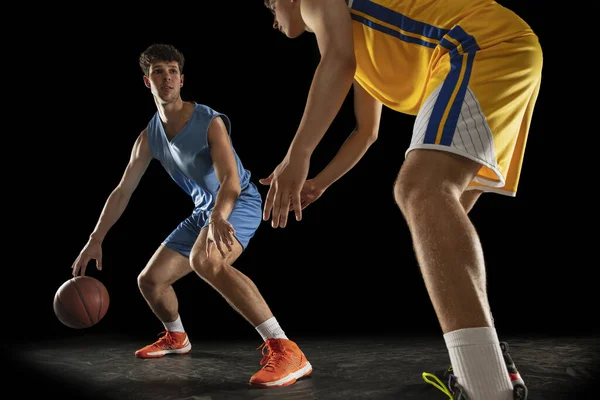 Desporto competitivo. Dois atletas do sexo masculino, jogadores profissionais de basquete em ação, movimento isolado sobre fundo preto. — Fotografia de Stock