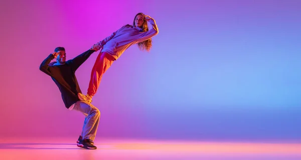 Een flyer. Twee jonge mensen, man en meisje dansen hedendaagse dans, hip-hop over roze achtergrond in neon licht. — Stockfoto