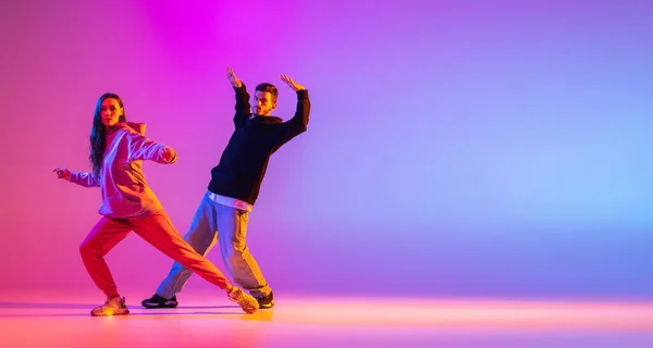 フライヤー。二人の若い人たち,男と女の子ダンス現代舞踊,ヒップホップピンクの背景にネオンの光. — ストック写真