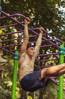 Spor giyim antrenmanında genç, yakışıklı beyaz bir adam açık havada spor yapıyor..