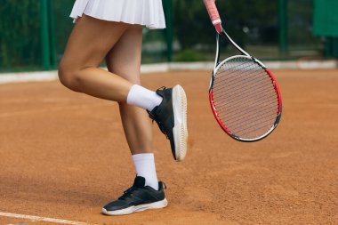 Tenis oynuyordum. Raketli kadın tenisçinin yakın plan görüntüsü. Kas bacakları