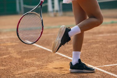 Tenis oynuyordum. Raketli kadın tenisçinin yakın plan görüntüsü. Kas bacakları