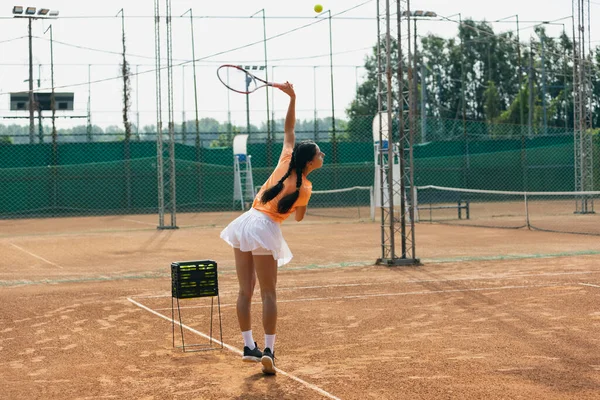 Gyönyörű fiatal sportoló, profi teniszező ütő gyakorló salak teniszpálya nyári napon. — Stock Fotó