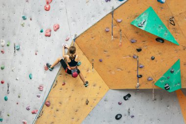 Tırmanma ekipmanlarıyla dışarıda taş duvarda pratik yapan sevimli bir genç kız. Küçük yürüyüşçü. Etkin yaşam tarzı kavramı