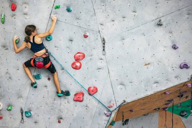 Tırmanma merkezinde taş duvarda pratik yapan tatlı bir genç kız. Sportif yaşam tarzı, aktivite, mutlu çocukluk kavramı