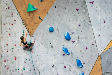 Tırmanma ekipmanlarıyla dışarıda taş duvarda pratik yapan sevimli bir genç kız. Küçük yürüyüşçü. Etkin yaşam tarzı kavramı
