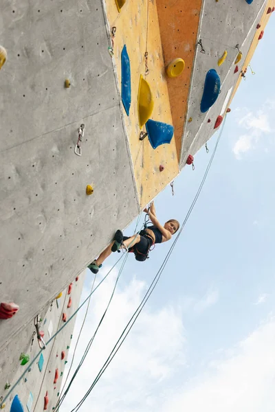Jeden słodkie nastolatek dziewczyna ćwiczenia na skale w centrum wspinaczka na tle nieba — Zdjęcie stockowe