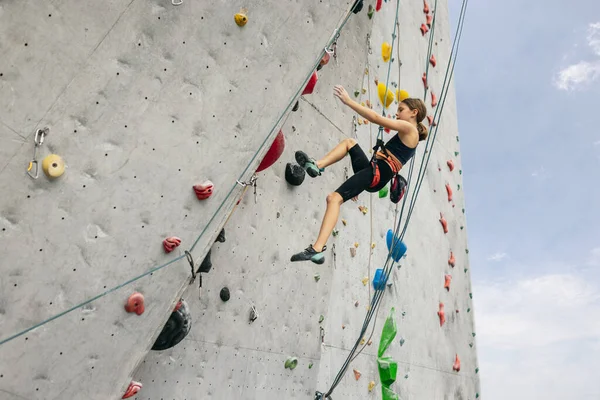 Jeden słodkie nastolatek dziewczyna ćwiczenia na skale w centrum wspinaczka na tle nieba — Zdjęcie stockowe