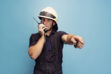 Üniformalı genç bir erkek itfaiyeci, yol tarifi ve koordinatları veriyor..