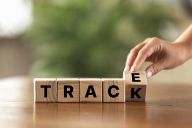 Ahşap masanın üzerinde iz bırakacak kelime parçalarıyla tahta küpleri çeviren bir kadın. Reklam için kopyalama alanı, teklif.