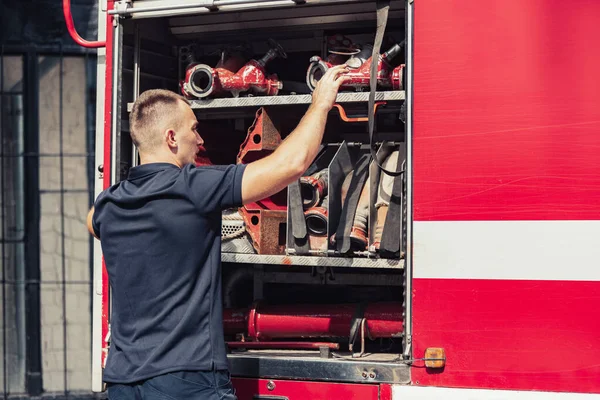 Пожежник стоїть на вантажівці зі спеціальним обладнанням — стокове фото