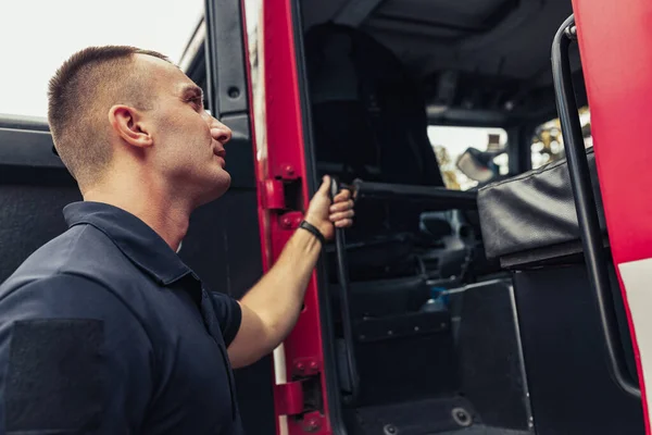 Пожежник пожежною машиною з використанням професійного пожежного обладнання — стокове фото