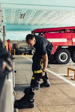 İtfaiyeci itfaiyede üniforma giyiyor.