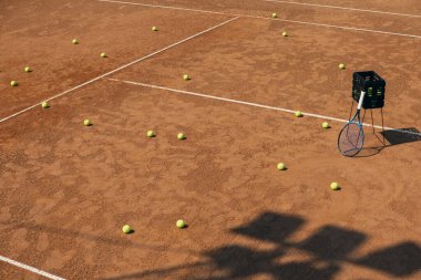 Raket ve sarı tenis toplarıyla tenis kortunun görüntüsü