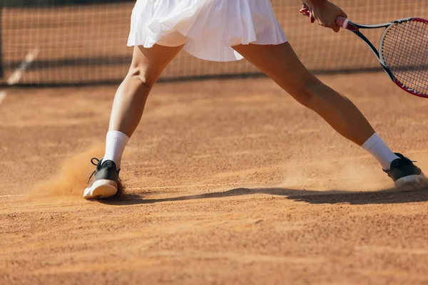 Oříznutý obrázek ženských nohou hrajících tenis na tenisovém kurtu — Stock fotografie