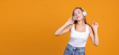 Hayat devam ediyor. Güzel kız neşeyle müzik dinliyor ve kulaklıkla dans ediyor.