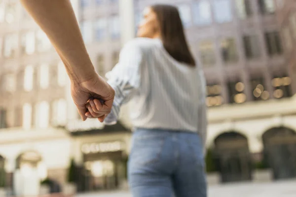 Обрізана фотографія тримання рук молодої пари під час літньої міської прогулянки — стокове фото