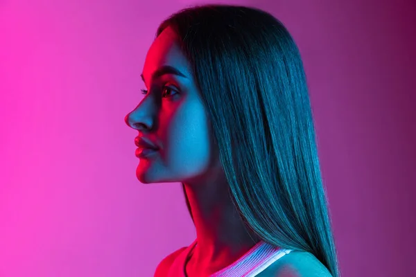Side-seen close-up portrét mladé krásné dívky izolované na růžové fialové pozadí studia — Stock fotografie