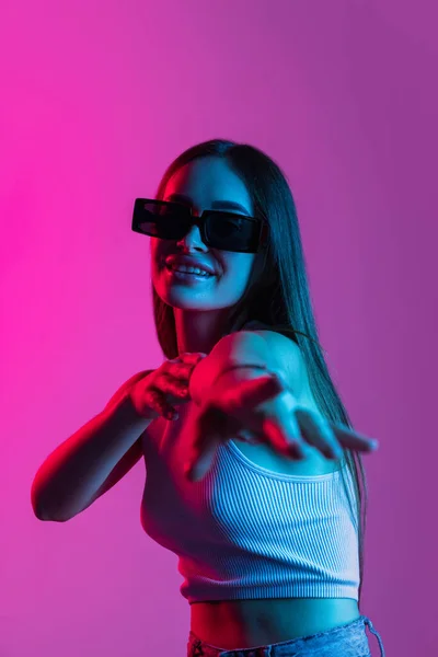 Ritratto di giovane bella ragazza in movimento isolato su sfondo viola rosa — Foto Stock