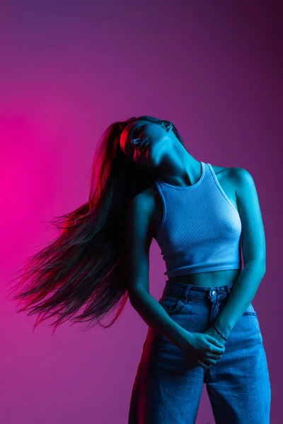 Mladá krásná dívka v pohybu izolované na růžové fialové pozadí — Stock fotografie