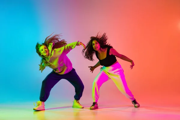 Dos jóvenes bailarines de hip-hop con estilo sobre fondo degradado colorido en luces de neón — Foto de Stock