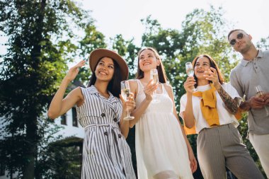 Aydınlık bir yaz gününde dört neşeli insan birlikte kırsalda vakit geçirir.