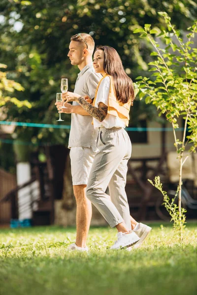 在温暖的夏日，一对年轻夫妇在花园散步的侧面全景肖像 — 图库照片