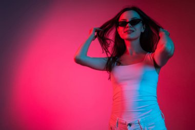 Genç ve güzel bir kızın gradyan pembe arka planda kesilmiş portresi.