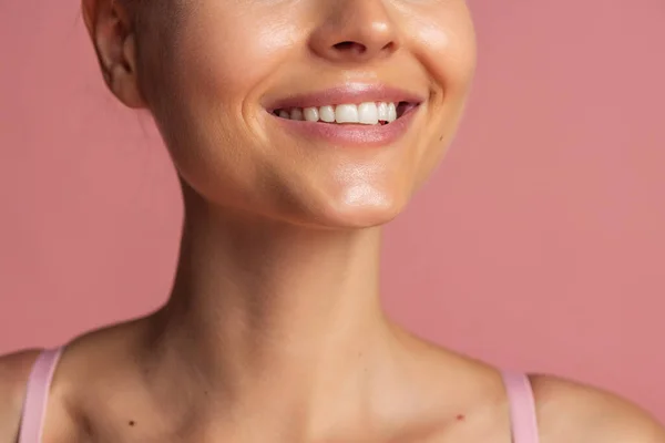 Potret gadis muda tersenyum terisolasi di atas latar belakang merah muda — Stok Foto