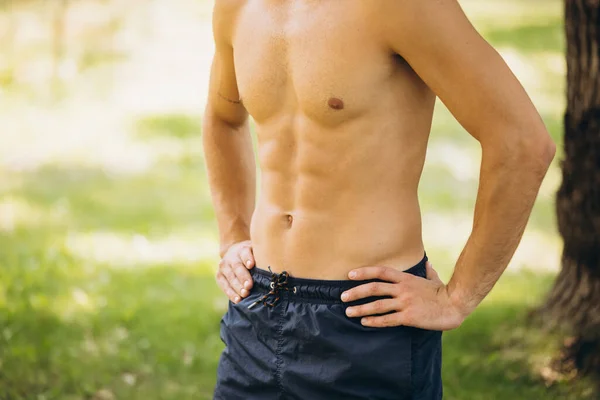 Cropped portrait of male sportive body isolated over outdoor background on bright summer day — Stock Photo, Image