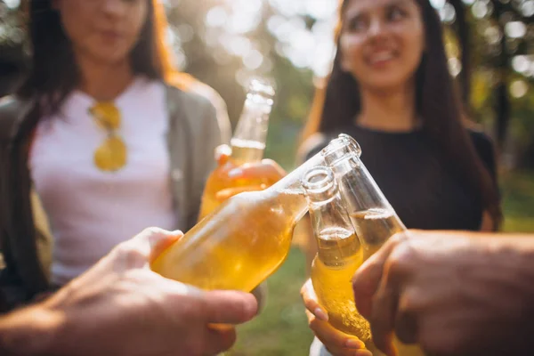 Immagine ravvicinata di mani ritagliate che tengono le bottiglie di birra che tintinnano. Alla salute. — Foto Stock
