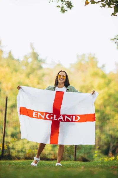 イギリスの旗を持つ若い美しい女の子の完全な長さの肖像画 — ストック写真