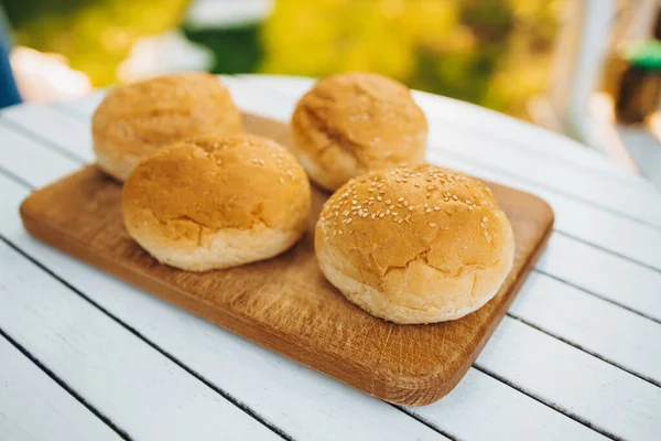 Вкусное изображение булочек для бургеров, лежащих на доске — стоковое фото