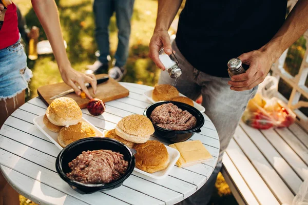 Amigos cozinhar juntos no campo para coleta de picninc no dia quente de verão — Fotografia de Stock