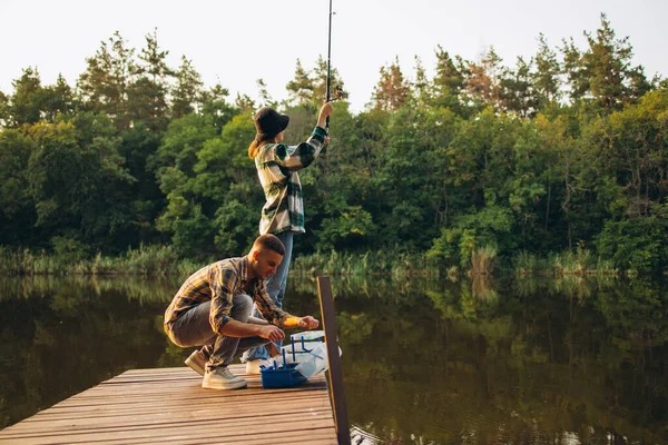 Ritratto di giovane coppia che pesca nella calda giornata estiva in campagna al tramonto — Foto Stock