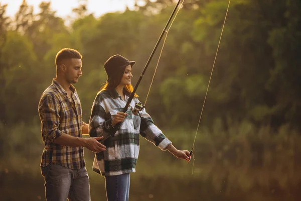 Retrato de pareja joven pescando en el cálido día de verano en el campo al atardecer — Foto de Stock
