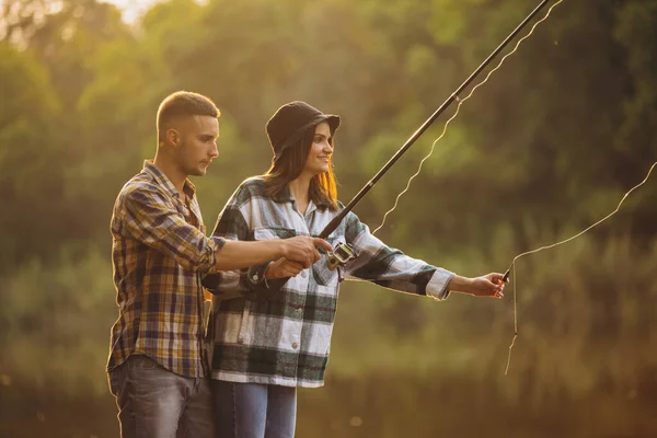 Retrato de pareja joven pescando en el cálido día de verano en el campo al atardecer — Foto de Stock