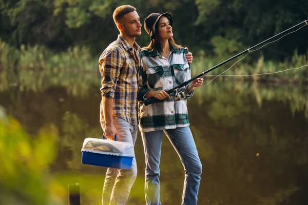 Ritratto di giovane coppia che pesca nella calda giornata estiva in campagna al tramonto — Foto Stock