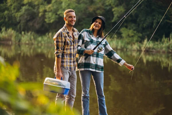 夕暮れ時の田舎の暖かい夏の日に若い夫婦釣りの肖像画 — ストック写真